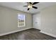 Spacious bedroom with ceiling fan, large window, wood-look floors, and a closet, blending comfort and functionality at 2919 Hughes Gasque Rd., Aynor, SC 29511