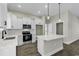 Modern kitchen featuring white cabinets, stainless appliances, quartz countertops, and stylish pendant lighting at 2919 Hughes Gasque Rd., Aynor, SC 29511