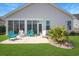 Backyard with a patio, colorful chairs, green grass, well manicured shrubbery, and a white exterior at 3024 Calusa Dr., Little River, SC 29566