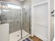 Modern bathroom featuring a tiled walk-in shower with a glass door and white trim at 3024 Calusa Dr., Little River, SC 29566