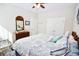 Comfortable bedroom with a decorative mirror, dresser, ceiling fan, and a cozy bed with blue accents at 3024 Calusa Dr., Little River, SC 29566