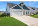Single-story home with a two-car garage, manicured lawn, and a welcoming front entrance under a clear blue sky at 3024 Calusa Dr., Little River, SC 29566