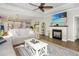 Inviting living room with a fireplace, ceiling fan, and open layout leading to the kitchen at 3024 Calusa Dr., Little River, SC 29566