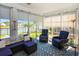 Inviting sunroom with wicker furniture, a blue patterned rug, and views of the community pond at 3024 Calusa Dr., Little River, SC 29566
