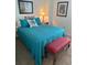 A well-decorated bedroom features a comfortable bed with turquoise linens, a bench, and stylish furnishings at 310 N 73Rd Ave. N # 5D, Myrtle Beach, SC 29572