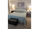 Well-lit bedroom features a queen bed with a light blue quilt, complementing the neutral walls and soft carpet at 310 N 73Rd Ave. N # 5D, Myrtle Beach, SC 29572