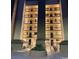 Multi-story condominium with balconies and stairs, at night, and illuminated with bright warm lighting at 310 N 73Rd Ave. N # 5D, Myrtle Beach, SC 29572