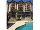 Resort condo building exterior featuring pool area, cabana, palm trees, balconies, and screened-in patios at 310 N 73Rd Ave. N # 5D, Myrtle Beach, SC 29572