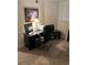 A home office features a black desk, ergonomic chair, lamp, and workspace essentials on neutral carpeting at 310 N 73Rd Ave. N # 5D, Myrtle Beach, SC 29572