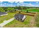 Aerial view of a modern farmhouse featuring a long driveway, large lawn and perimeter fence at 3117 Chapel Rd., Loris, SC 29569