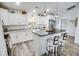 Well-lit kitchen with white cabinetry, granite countertops, a central island with bar seating, and stainless steel appliances at 3117 Chapel Rd., Loris, SC 29569
