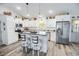 Bright kitchen featuring white cabinetry, stainless steel appliances, a kitchen island with barstools, and hardwood flooring at 3117 Chapel Rd., Loris, SC 29569