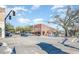 Bustling street view showcasing a brick building with awnings, a tree, and various parked cars under a sunny sky at 3324 Little Bay Dr., Conway, SC 29526