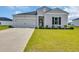 Inviting one-story home featuring gray siding, a well-kept lawn, and an attached one-car garage at 366 Fennec Loop, Conway, SC 29526