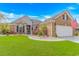 Beautiful front yard with lush landscaping, charming brick exterior, and a well-maintained lawn for curb appeal at 3907 Club Course Dr., North Myrtle Beach, SC 29582