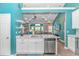 An open kitchen with stainless steel appliances and white cabinets overlooks a living room area, perfect for entertaining at 3907 Club Course Dr., North Myrtle Beach, SC 29582