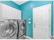 A modern laundry room includes stainless steel washer and dryer with a door to the exterior at 3907 Club Course Dr., North Myrtle Beach, SC 29582