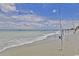 Wide sandy beach with surf and a few people, along with fishing poles in the sand at 404 75Th Ave N # G, Myrtle Beach, SC 29572