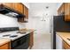 Kitchen with wood cabinets, white countertops, tile flooring, and a view into the adjacent dining/living area at 404 75Th Ave N # G, Myrtle Beach, SC 29572