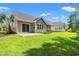 The back of the home features a patio, large glass doors, and green grass at 4165 Eva Bay Dr., Murrells Inlet, SC 29576