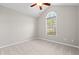 This bedroom has neutral paint, carpet, ceiling fan, and a window with a half circle feature at the top at 4165 Eva Bay Dr., Murrells Inlet, SC 29576
