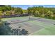 Aerial view of multiple tennis courts with nets in a wooded community at 4165 Eva Bay Dr., Murrells Inlet, SC 29576