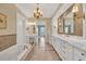 Elegant bathroom with dual vanities, tile flooring, chandelier, and a large soaking tub at 4204 N Ocean Blvd., Myrtle Beach, SC 29577