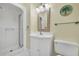 Well-lit bathroom with a framed mirror, shower with white fixtures, and a white toilet at 4204 N Ocean Blvd., Myrtle Beach, SC 29577
