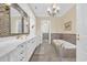 Luxurious bathroom with double sinks, marble countertops, mosaic tile accents, and a soaking tub at 4204 N Ocean Blvd., Myrtle Beach, SC 29577