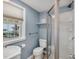 Comfortable bathroom with light blue walls, a shower with a glass door and a large window at 4204 N Ocean Blvd., Myrtle Beach, SC 29577