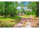 Exterior shot of home featuring a yard with trees and a metal structure; a long driveway leading to the residence at 4391 Party Pines Rd., Conway, SC 29526