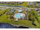 Aerial view of a community pool and tennis courts surrounded by lush landscaping and a serene lake at 4425 Honir Dr., Myrtle Beach, SC 29579