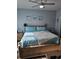 Comfortable bedroom with a wooden bed frame, soft blue bedding, side tables, and coastal-themed decor at 4449 Turtle Ln. # 3A, Little River, SC 29566