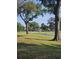 Peaceful green space with a view of a building in the distance, framed by large trees at 4449 Turtle Ln. # 3A, Little River, SC 29566