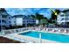 Community pool is surrounded by lounge chairs and a white fence with condos in the background at 4449 Turtle Ln. # 3A, Little River, SC 29566