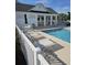 Lounge chairs sit poolside with a clubhouse in the background, perfect for relaxation at 4449 Turtle Ln. # 3A, Little River, SC 29566