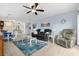 Living room with black sofa, blue walls, tile flooring, and a view of the kitchen and dining area at 4500 S Ocean Blvd. # 4, North Myrtle Beach, SC 29582