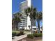 Beautiful exterior view of condo building and lush landscaping with palm trees on a sunny day at 5511 North Ocean Blvd. # 105, Myrtle Beach, SC 29577