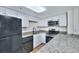 Updated kitchen with granite countertops, white cabinetry, and modern black appliances at 5511 North Ocean Blvd. # 105, Myrtle Beach, SC 29577