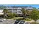 Three-story condo building with white trim, multiple balconies, and well-maintained landscaping in a sunny parking area at 5751 Oyster Catcher Dr. # 431, North Myrtle Beach, SC 29582