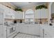 Bright kitchen with white appliances, patterned wallpaper, and overhead cabinetry at 5751 Oyster Catcher Dr. # 431, North Myrtle Beach, SC 29582