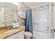 Bright bathroom featuring a granite countertop, shower-tub combo, and tropical-themed wallpaper at 6001 N Ocean Blvd. # 147, North Myrtle Beach, SC 29582