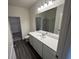 Bathroom featuring a long vanity with white countertop, large mirror, and a view of the walk-in closet at 624 Muster Field Ct., Conway, SC 29526