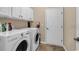 Functional laundry room with modern washer and dryer units and ample cabinet space, ensuring convenient chore management at 632 Serendipity Circle, Murrells Inlet, SC 29576