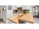 View of kitchen with stone backsplash, stainless steel appliances, butcher block countertops, and white cabinets at 679 Riverwalk Dr. # 202, Myrtle Beach, SC 29579