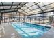 Indoor pool featuring a glass ceiling and surrounded by lounge chairs at 679 Riverwalk Dr. # 202, Myrtle Beach, SC 29579