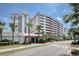 View of a condominium building with a connected parking garage and beautiful tropical landscaping at 7200 Ocean Blvd. N # 664, Myrtle Beach, SC 29572