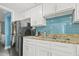 Kitchen with modern appliances, granite counters, and a stylish blue tile backsplash at 7200 Ocean Blvd. N # 664, Myrtle Beach, SC 29572