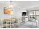 Bright living room with dining table, television, and a sliding glass door to a balcony at 7200 Ocean Blvd. N # 664, Myrtle Beach, SC 29572