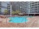A refreshing outdoor pool surrounded by lounge chairs, palm trees, and towering condos for vacation relaxation at 7200 Ocean Blvd. N # 664, Myrtle Beach, SC 29572